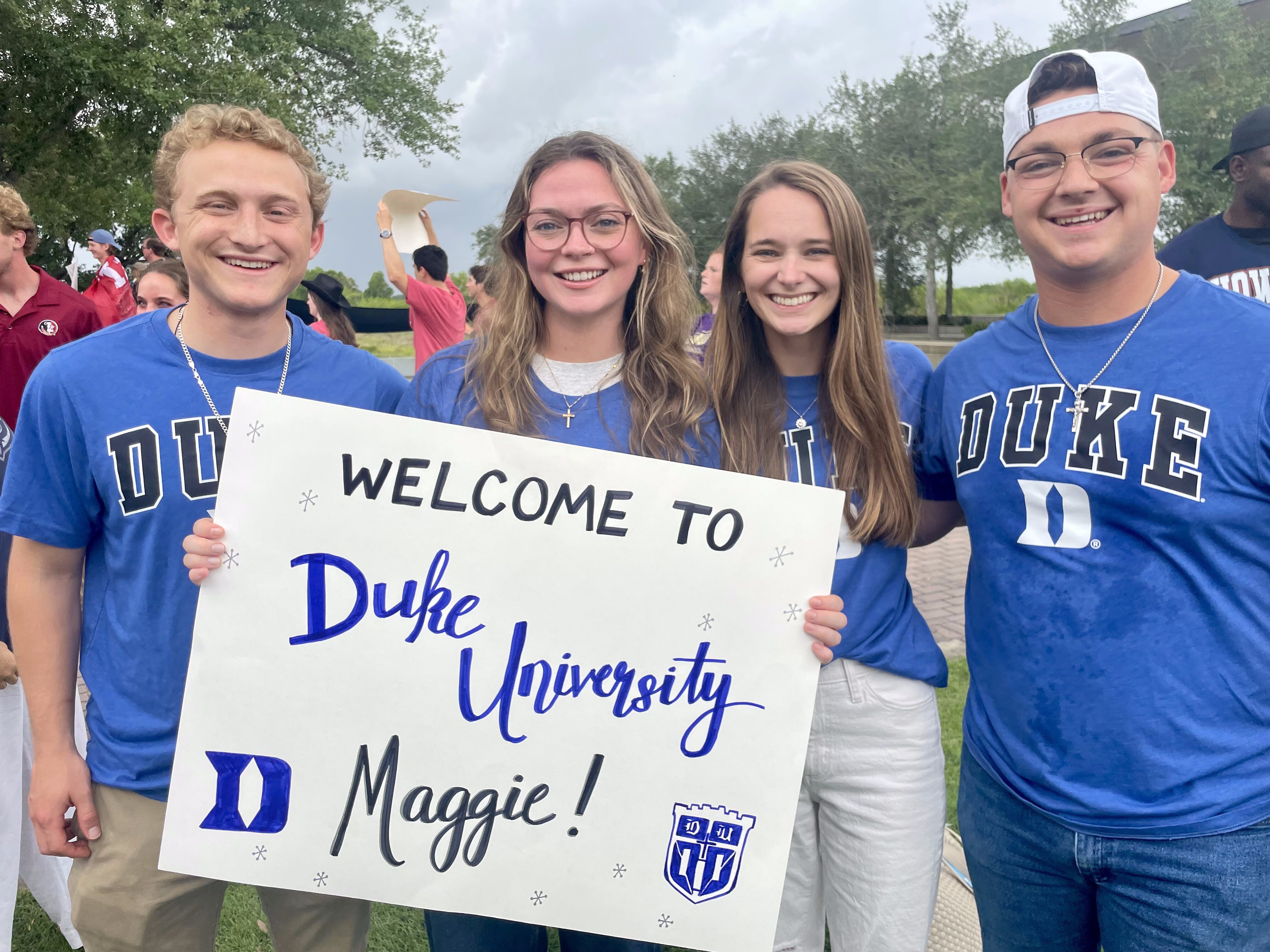 Four Duke Missionaries holding a poster