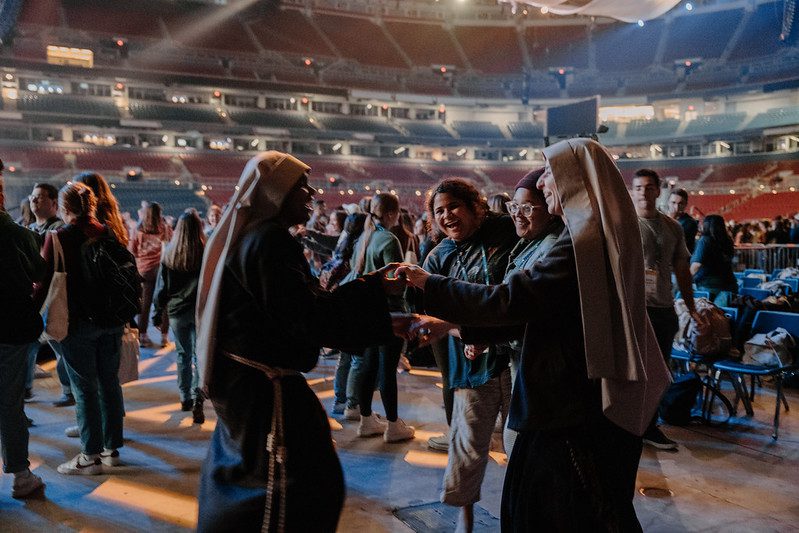 Nuns chat together at a FOCUS SEEK conference. This article is about discerning your vocation, and it shows young people interacting with them. 