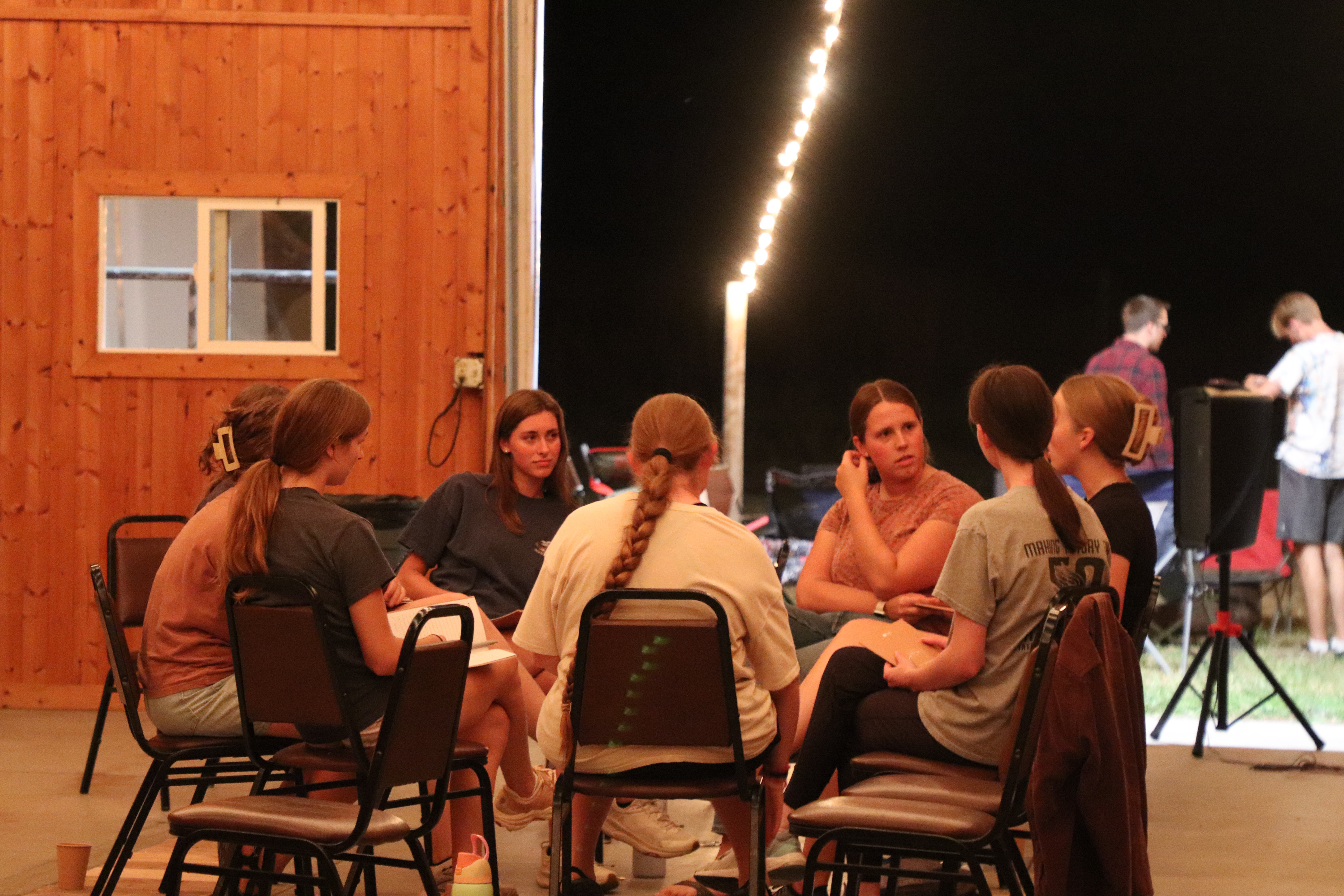 Friends gather outdoors in a circle to do a Bible Study