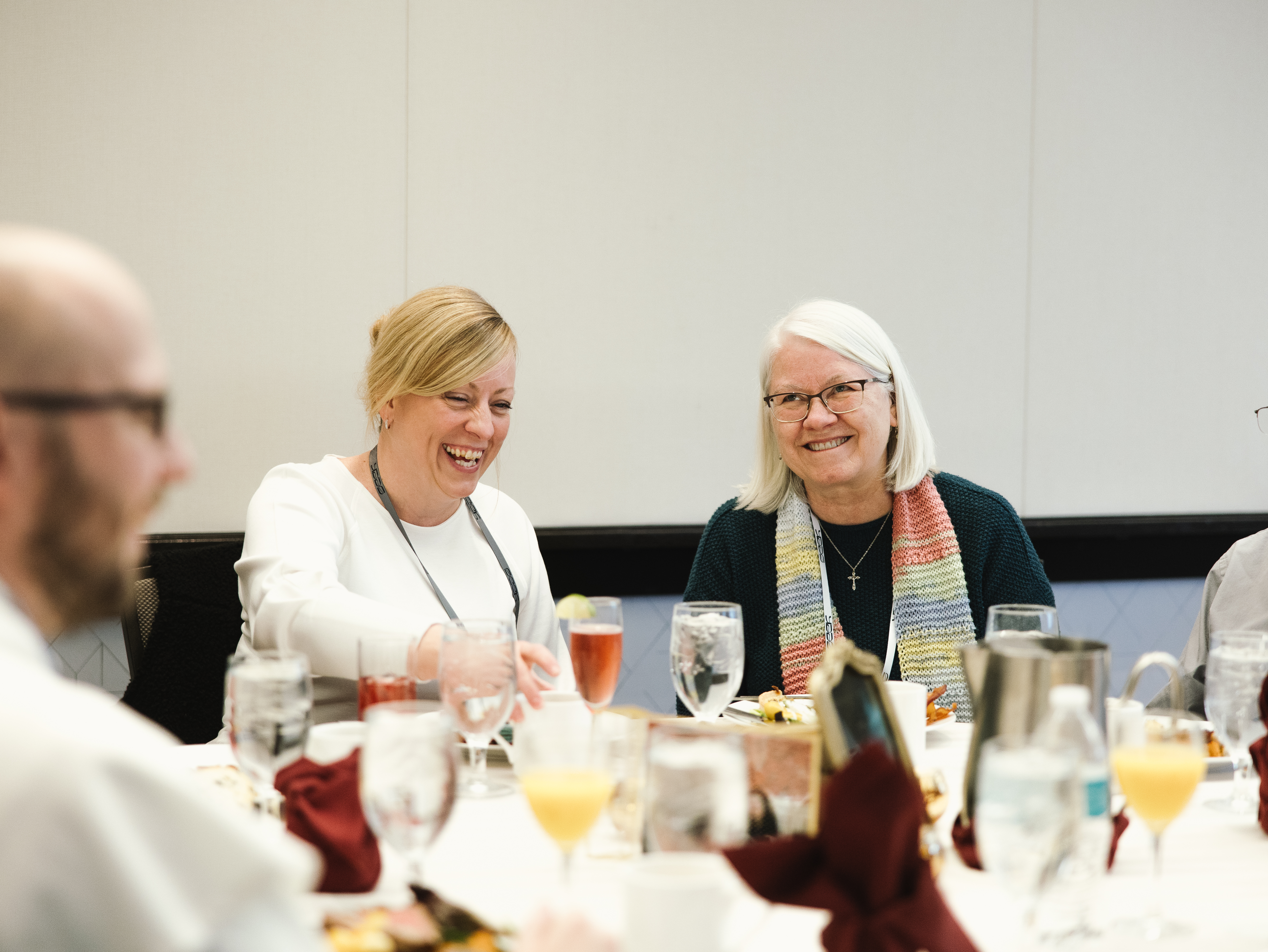 Two women and a man enjoy refreshments at a SEEK Local event in their town. 