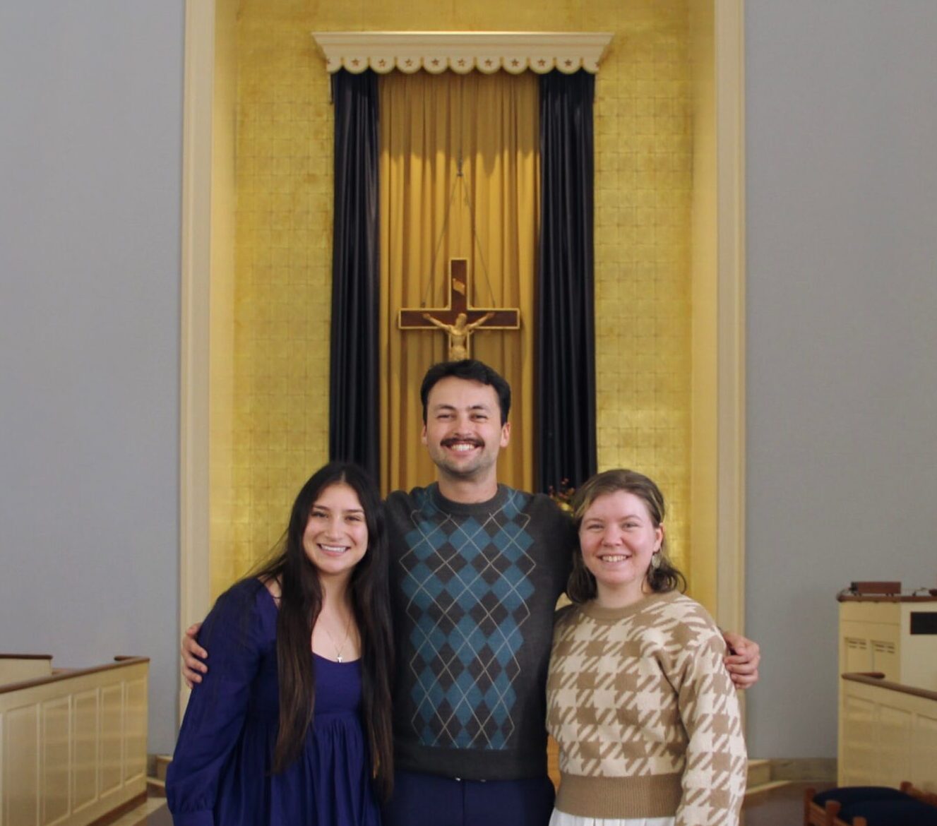 a photo of three people - woman, man, woman - in a church
