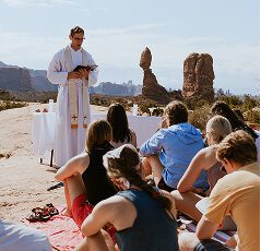 priest delivering sermon outside