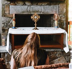 lady kneeling before the eucharist