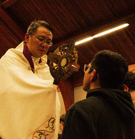 man praying with priest holding monstrance over him (1)