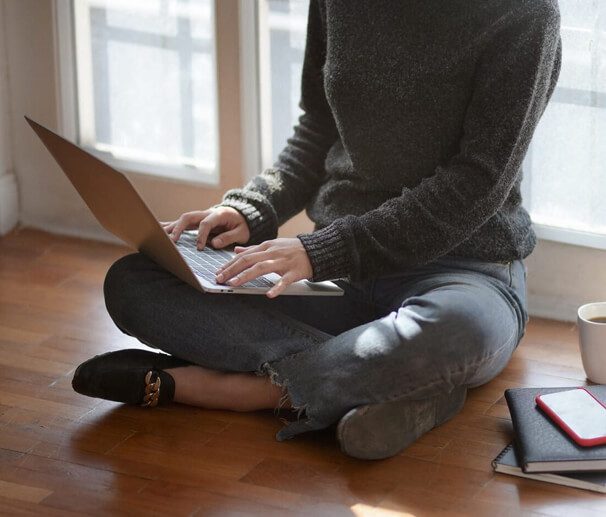 lady sitting on floor with laptop on lap