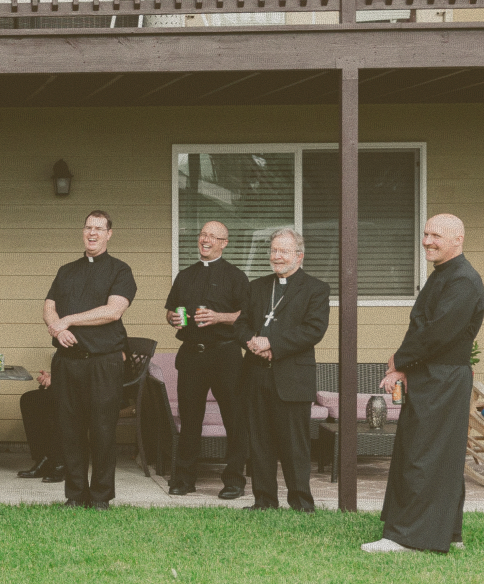 Group of priests standing together and laughing